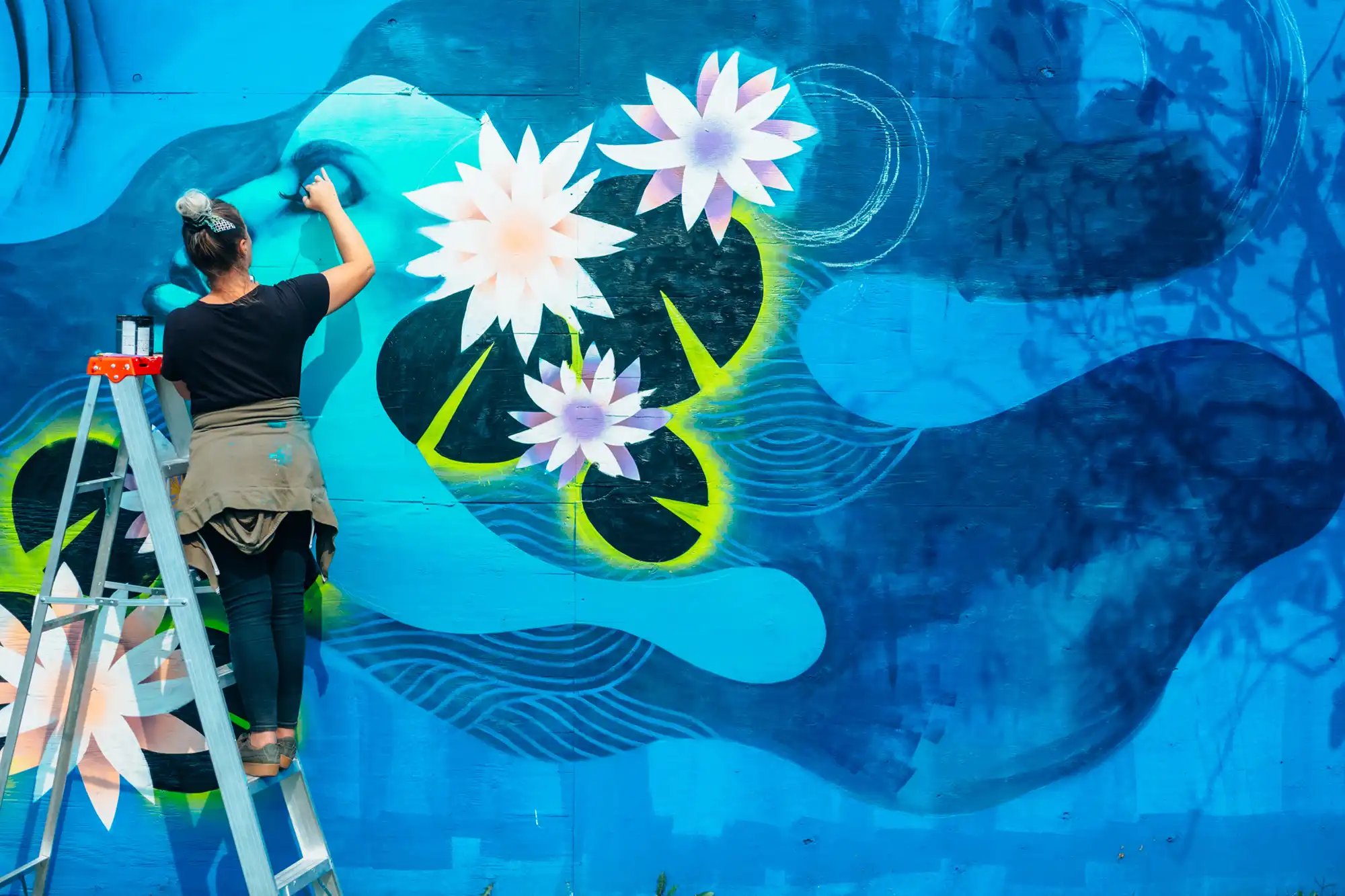 indigo-community-woman-painting-public-mural