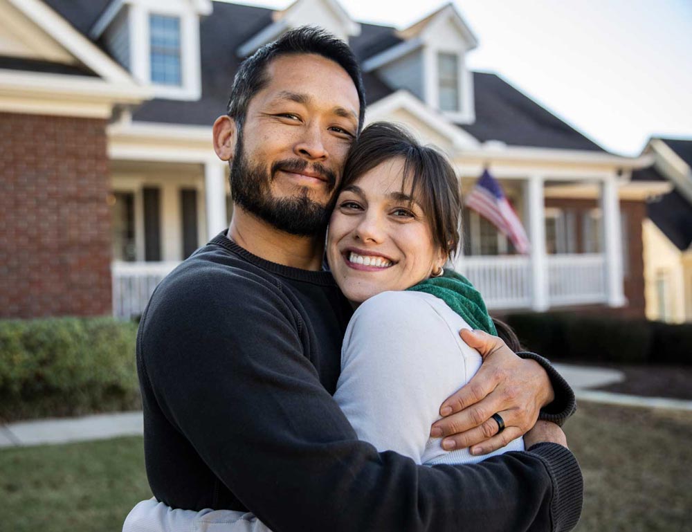 happy-couple-in-front-of-house